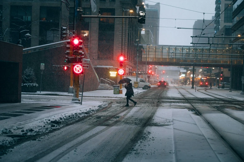 a person walking across a snow covered street, inspired by Elsa Bleda, unsplash contest winner, minneapolis, intersection, red light, post apocalyptic street