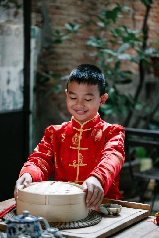 a little boy that is standing in front of a cake, an album cover, inspired by Gong Xian, pexels contest winner, playing drums, qing dynasty, delightful surroundings, he is a long boi ”