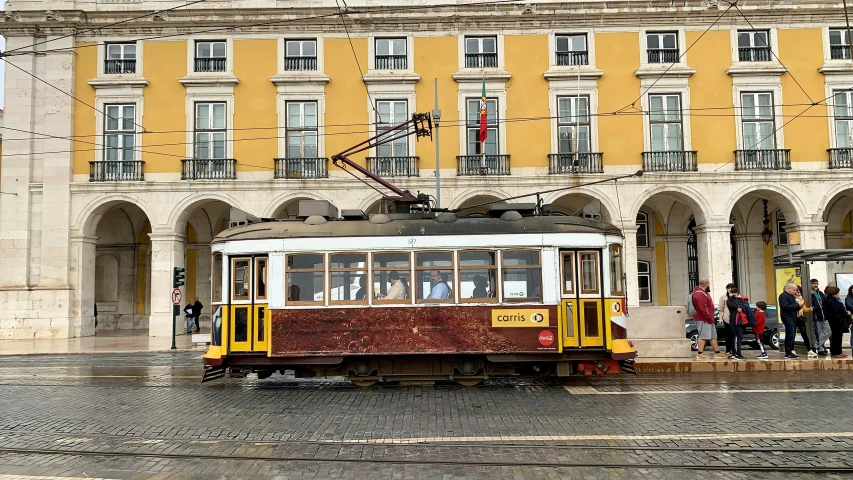 a trolley car on a city street in front of a building, by Tom Wänerstrand, pexels contest winner, on a great neoclassical square, brazilian ronaldo, brown, grey
