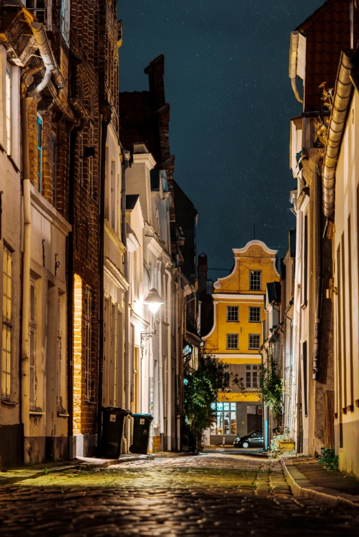 a cobblestone street at night with a clock tower in the background, by Jan Tengnagel, renaissance, buttresses, hull, exterior, brown