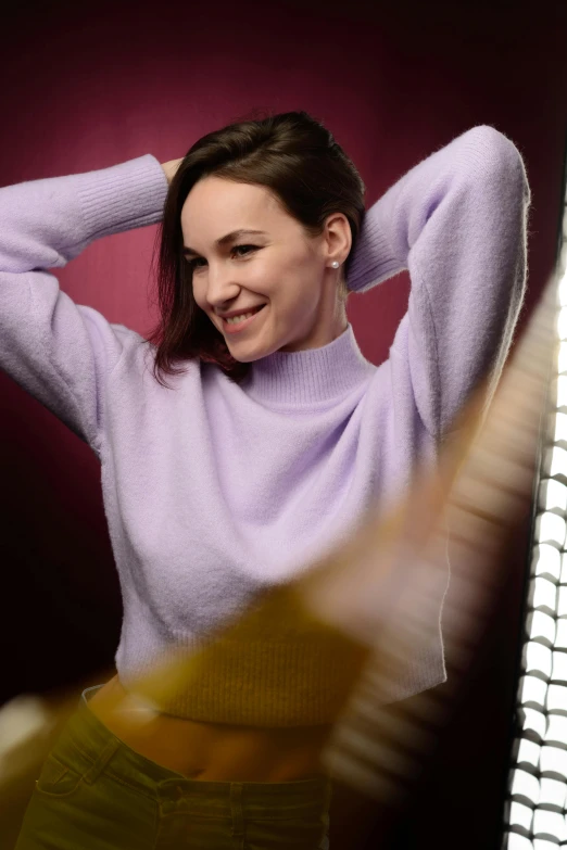 a woman that is standing in front of a mirror, a portrait, inspired by Zoë Mozert, trending on pexels, wearing casual sweater, purple volumetric lighting, happy fashion model, film still of gal gadot