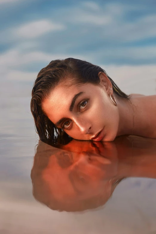 a woman laying on top of a body of water, flawless features, wet make - up, shot with sony alpha 1 camera, dune