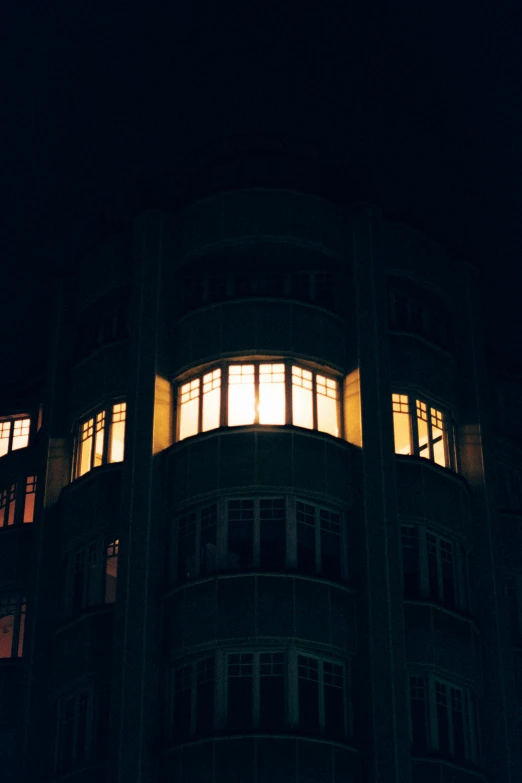 a tall building with lots of windows lit up at night, an album cover, unsplash, berlin secession, soviet apartment, vsco, yellowed, night photo