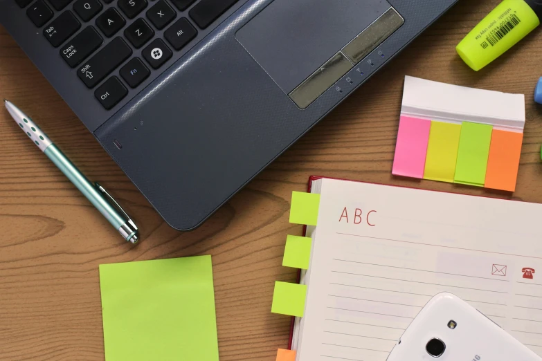 a laptop computer sitting on top of a wooden desk, notes, fluorescent colours, thumbnail, organized