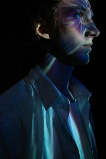 a man with blue light on his face, an album cover, inspired by Russell Dongjun Lu, trending on pexels, holography, androgynous male, high contrast light and shadows, fashion portrait, conor walton