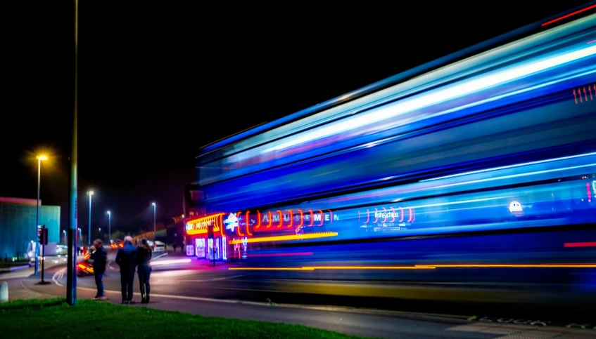 a blurry picture of a city street at night, by Jan Rustem, unsplash, happening, bus, lightpainting, profile shot, multi colour