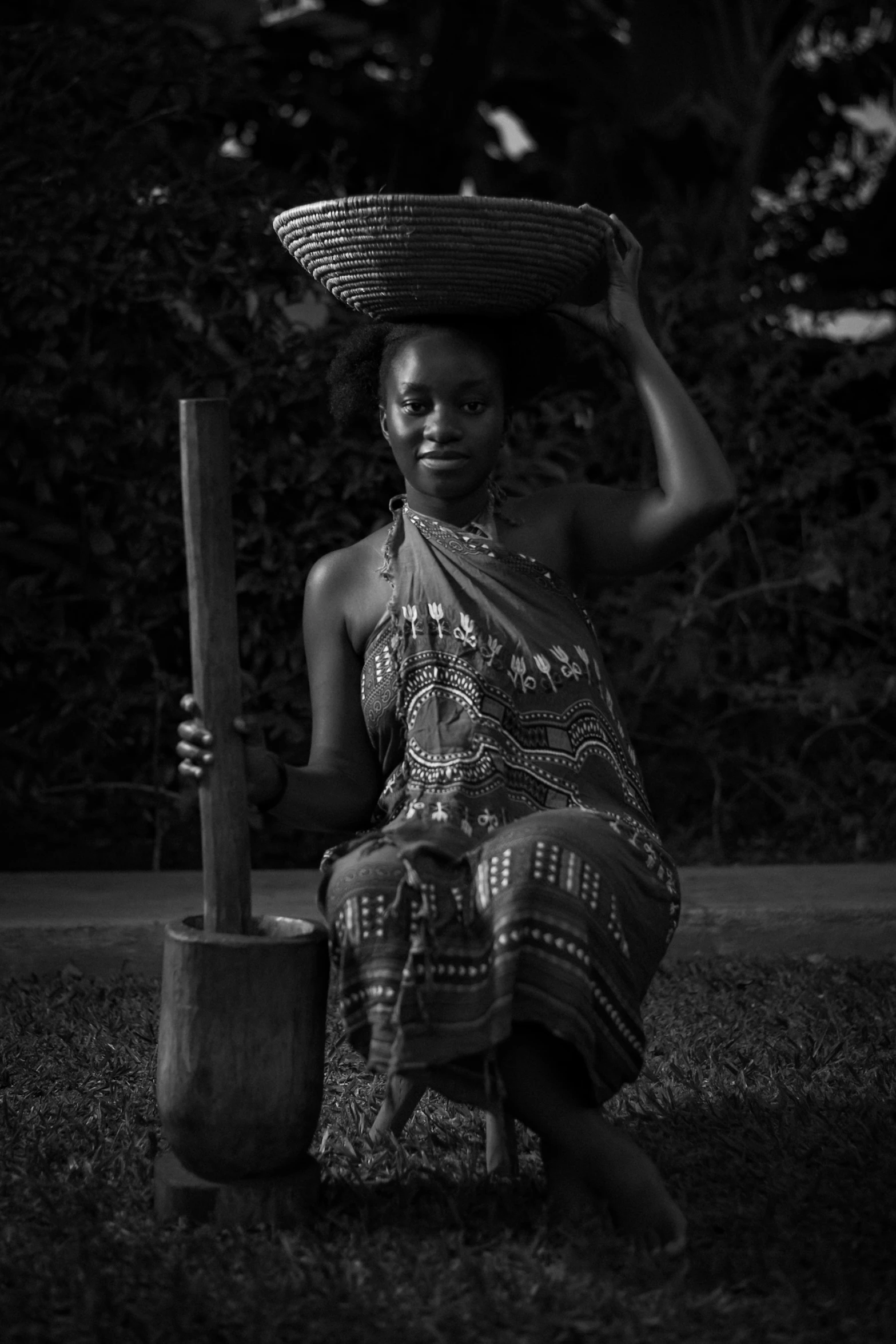 a black and white photo of a woman with a basket on her head, a black and white photo, inspired by Chinwe Chukwuogo-Roy, g cgsociety, seated, medium format, lowres