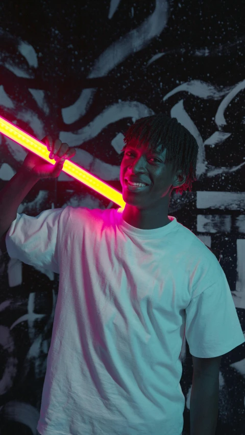 a man standing in front of a wall holding a neon sword, an album cover, inspired by Xanthus Russell Smith, pexels contest winner, black teenage boy, led light strips, looking happy, small red lights