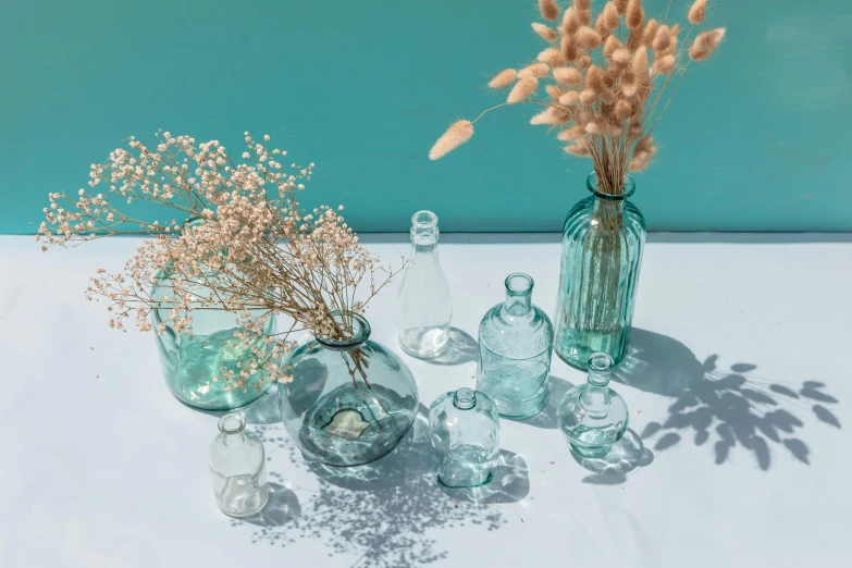 a group of vases sitting on top of a table, trending on pexels, teal sky, lots of glass details, apothecary, detailed product shot