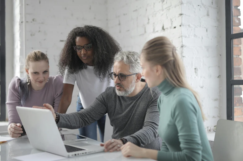 a group of people gathered around a laptop, by Andries Stock, pexels, grey, avatar image, instruction, adult