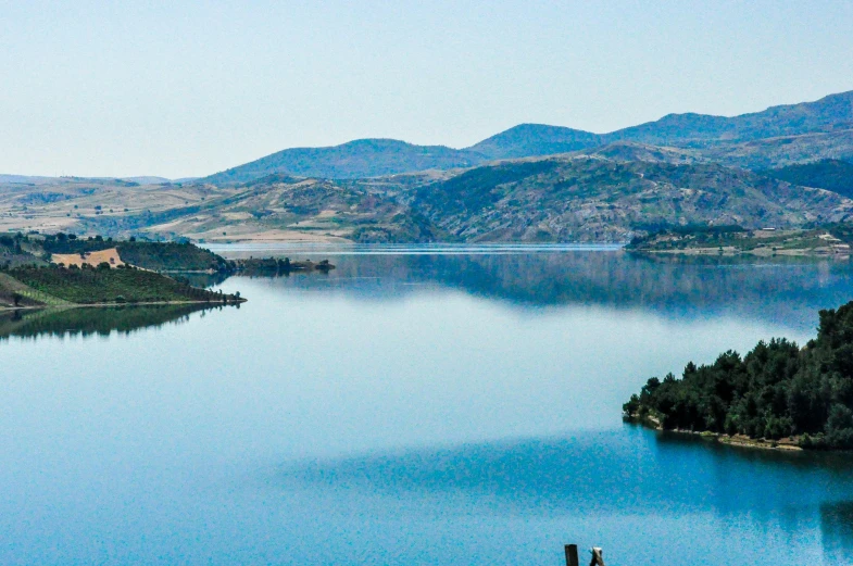 a large body of water with mountains in the background, a photo, hurufiyya, lake blue, listing image, multiple stories, waneella