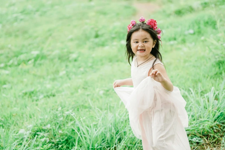 a little girl that is standing in the grass, inspired by Kate Greenaway, pexels contest winner, beautiful asian girl, running towards camera, rose crown, white background