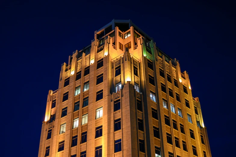 a tall building is lit up at night, an art deco sculpture, inspired by Hugh Ferriss, flickr, architecture photo, new mexico, getty images, four stories high