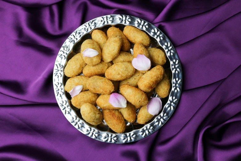 a bowl filled with food sitting on top of a purple cloth, hurufiyya, chicken nuggets, hindu aesthetic, silver platter, thumbnail