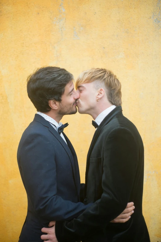 a couple of men standing next to each other, an album cover, by Liza Donnelly, pexels contest winner, renaissance, kissing together cutely, bargello, men in tuxedos, a blond