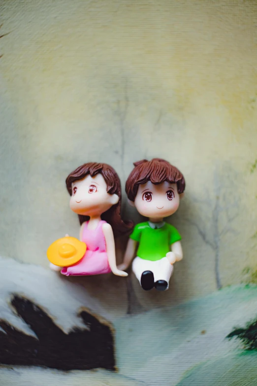 a couple of figurines sitting next to each other, a picture, inspired by Chiho Aoshima, pexels contest winner, plasticine, romantic scene, top down view, teenager
