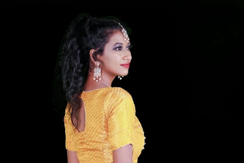 a woman in a yellow dress posing for a picture, by Sudip Roy, pixabay, hurufiyya, traditional female hairstyles, nigth, 2019 trending photo, looking from shoulder