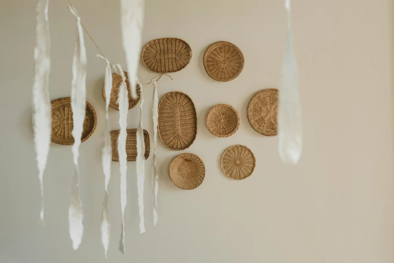 a bunch of baskets hanging on a wall, by Sylvia Wishart, pexels contest winner, folk art, fingerprints on clay, clean minimalist design, conceptual installation, brown