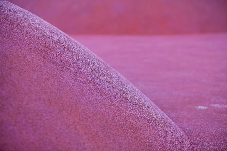 a large pile of sand sitting on top of a beach, a macro photograph, inspired by Scarlett Hooft Graafland, unsplash, color field, rich deep pink, iridiscent fabric, ((pink)), made of liquid purple metal