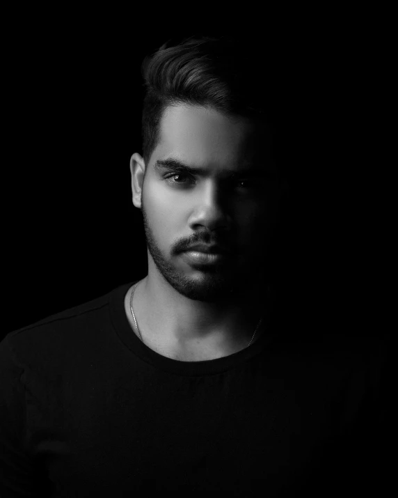 a black and white photo of a man with a beard, by Robbie Trevino, pexels contest winner, hurufiyya, non binary model, indian super model, discord profile picture, he is wearing a black t-shirt