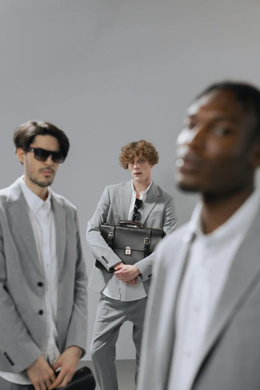 a group of men standing next to each other, trending on pexels, renaissance, grey suit, focus on model, ignant, people at work