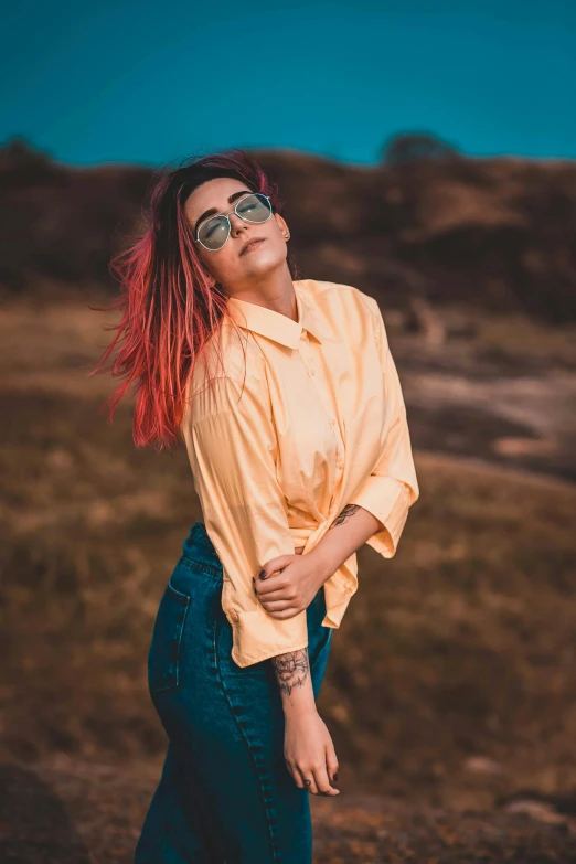 a woman with red hair standing in a field, trending on pexels, color field, wearing a shirt, bright hair, with a cool pose, cinematic outfit photo