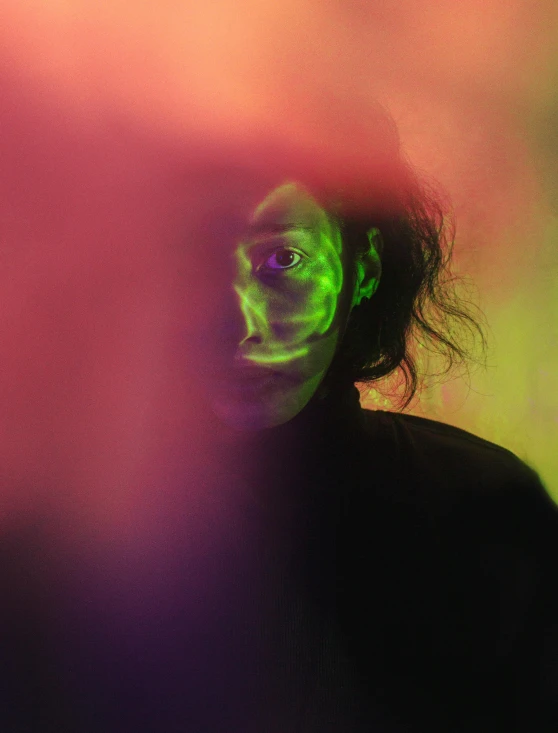 a man with green paint on his face, inspired by Elsa Bleda, pexels contest winner, glowing aura around her, databending, photo of a black woman, trapped egos in physical reality