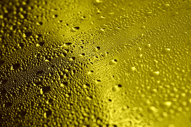 a close up of water droplets on a glass, a macro photograph, by Thomas Häfner, lyrical abstraction, yellow wallpaper, surface with beer-texture, gilt metal, mobile wallpaper