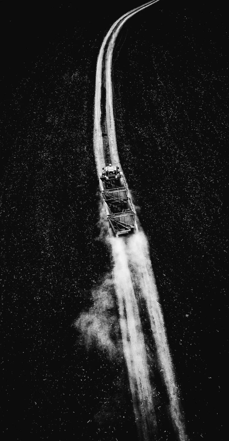 a black and white photo of a car driving down a road, by Thomas Fogarty, auto-destructive art, arial shot, boat, thumbnail, dust