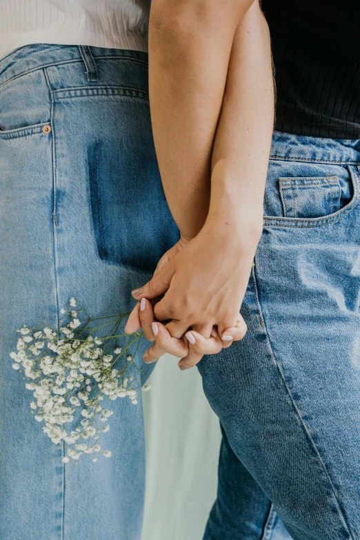 a close up of two people holding hands, by Cosmo Alexander, trending on unsplash, romanticism, carrying flowers, wearing blue jean overalls, lgbtq, julia hetta