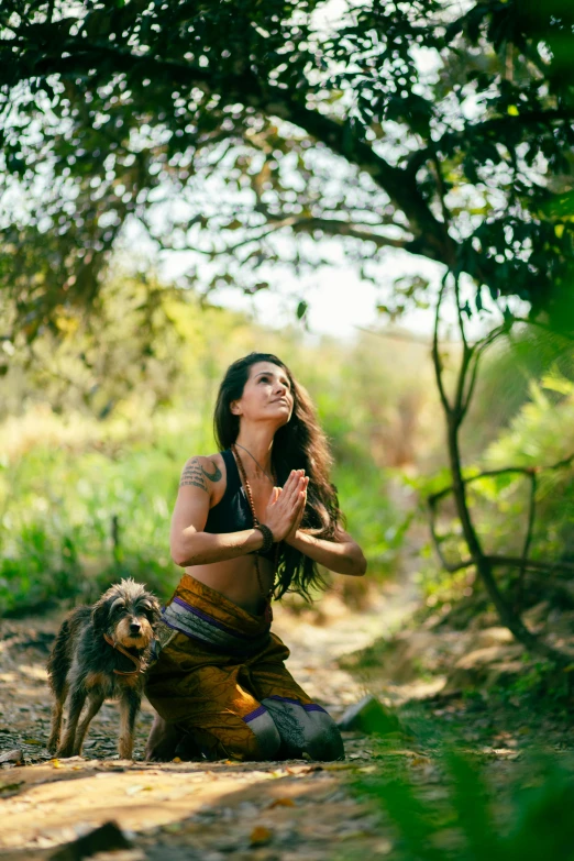 a woman meditating in the forest with her dog, a portrait, unsplash, brunette fairy woman stretching, slide show, tribal clothing, profile image