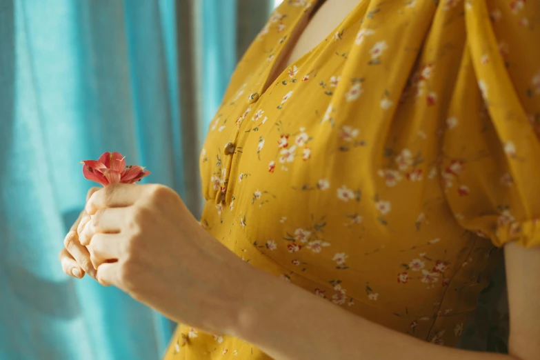 a woman in a yellow dress holding a red flower, trending on pexels, floral clothes, avatar image, pressed flowers, wearing a shirt