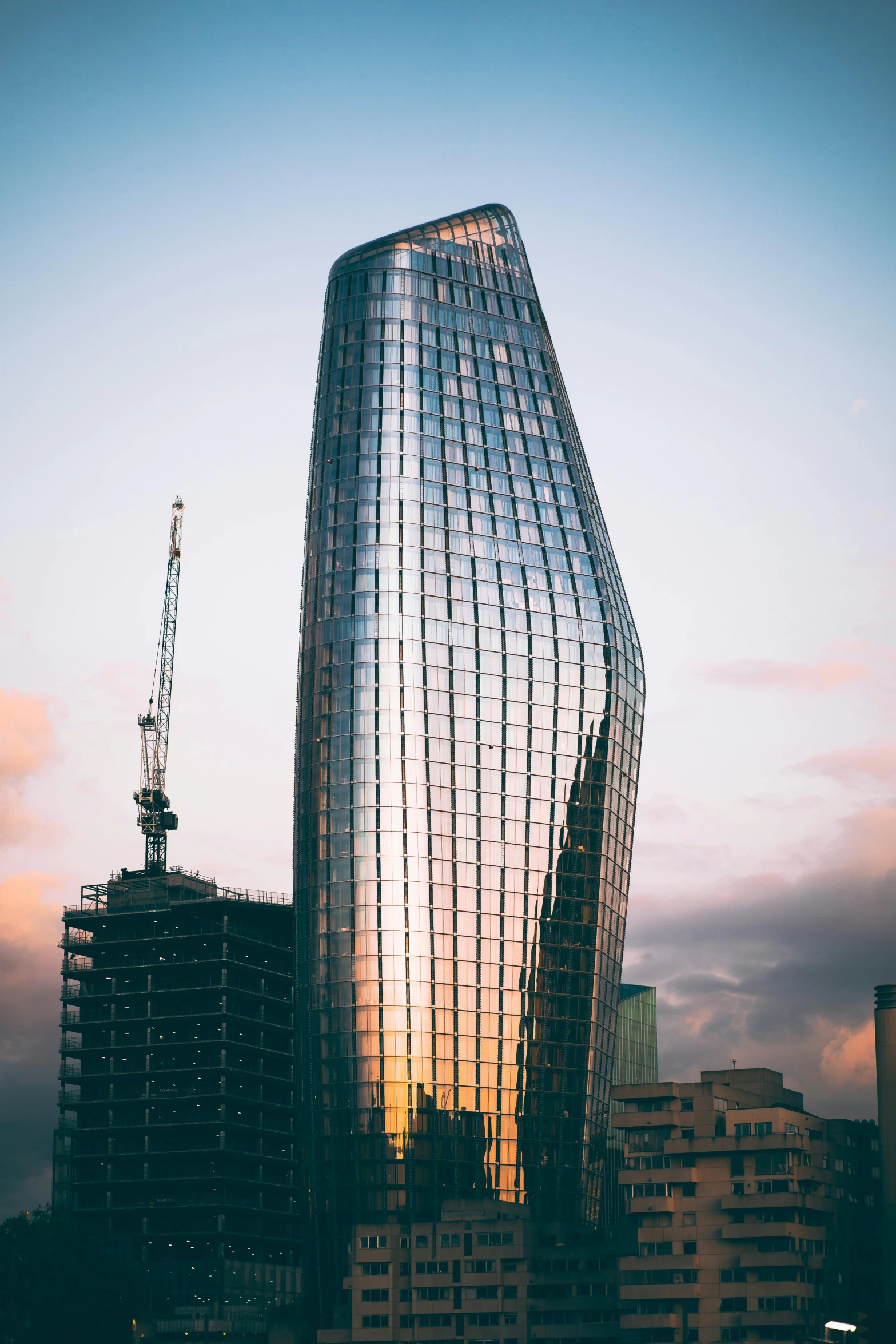 a very tall building sitting in the middle of a city, inspired by Zaha Hadid, unsplash contest winner, dappled in evening light, london, glass spaceship, under construction