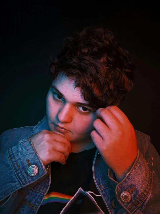 a close up of a person wearing a denim jacket, an album cover, by Ryan Pancoast, trending on pexels, realism, dramatic smirk pose, bisexual lighting, 1 6 years old, thicc