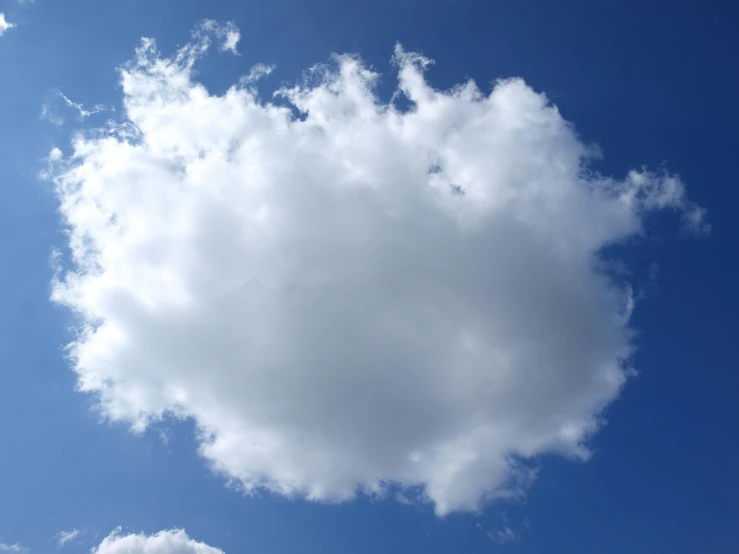 a white cloud in the middle of a blue sky, looking upwards, voluminous, cloud storage, slightly sunny