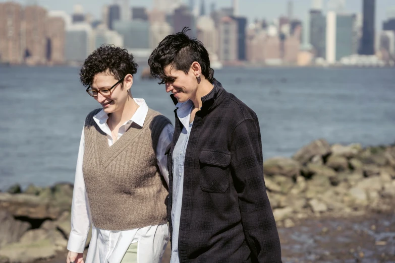 a man and a woman walking next to a body of water, a portrait, rebecca sugar, brooklyn, lesbians, full frame image