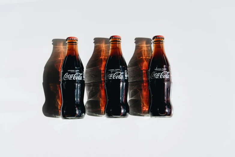 three bottles of coke sitting next to each other, by Carey Morris, trending on unsplash, hyperrealism, 6 pack, gradient brown to red, forward facing, ffffound