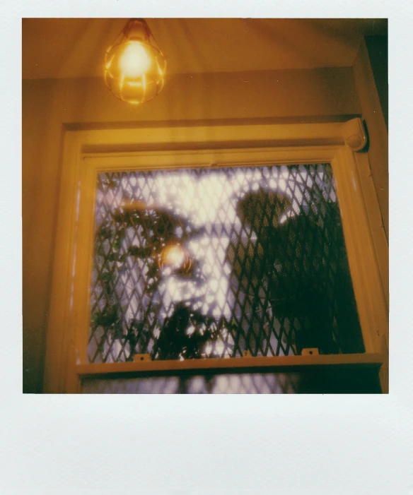 a close up of a window with a light, a polaroid photo, inspired by Elsa Bleda, porches, an intruder, ( ( photograph ) ), taken in the 2000s