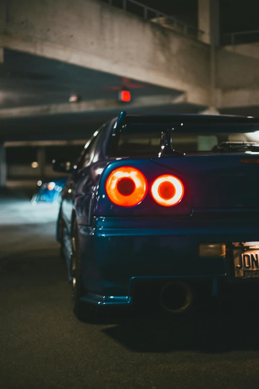 a blue sports car parked in a parking garage, a photo, by Winona Nelson, unsplash contest winner, in a modified nissan skyline r34, tail lights, 15081959 21121991 01012000 4k, nightlife