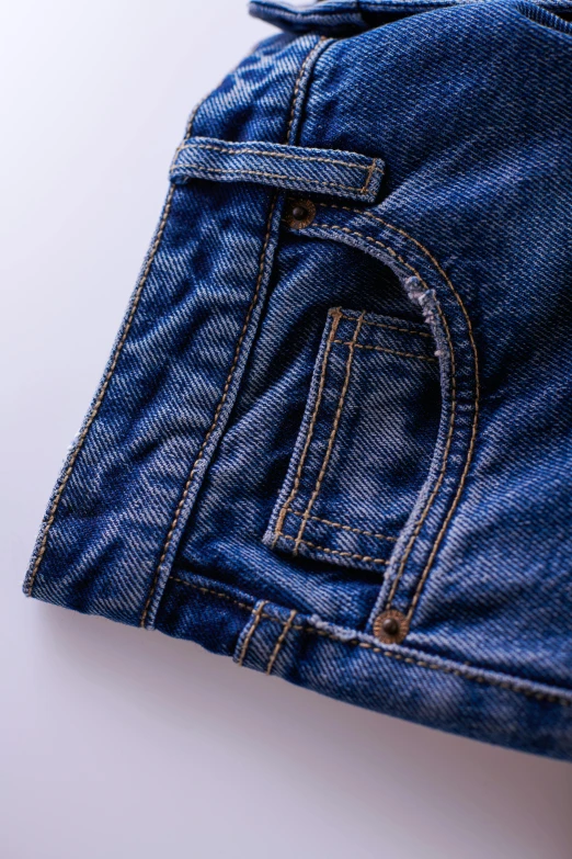 a pair of jeans sitting on top of a table, zoomed in, detailed product image, hyper - detailed color photo, detail shot