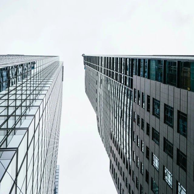 a couple of tall buildings next to each other, by Adam Rex, pexels contest winner, on grey background, glass ceilings, looking to the right, high angle vertical