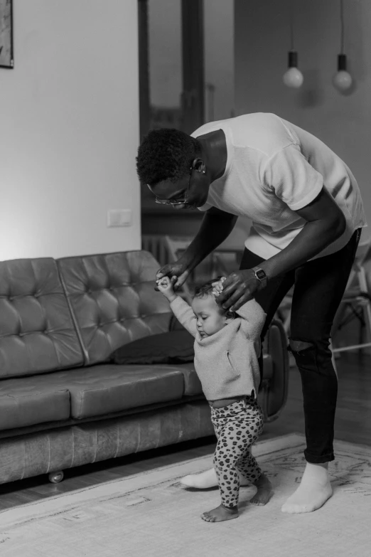 a man standing next to a little girl in a living room, a black and white photo, by Sam Charles, pexels contest winner, he is dancing, jaylen brown, young thug, beautiful man