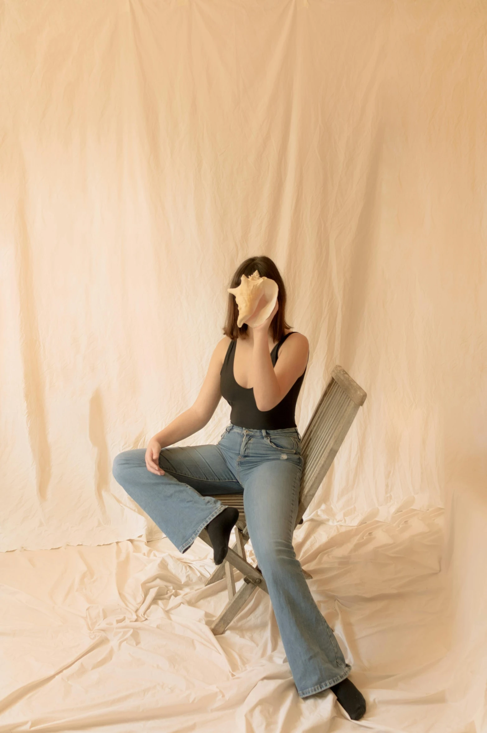 a woman sitting on a chair talking on a cell phone, an album cover, by Gee Vaucher, pexels contest winner, aestheticism, jeans, slightly minimal, gongbi, woman is curved