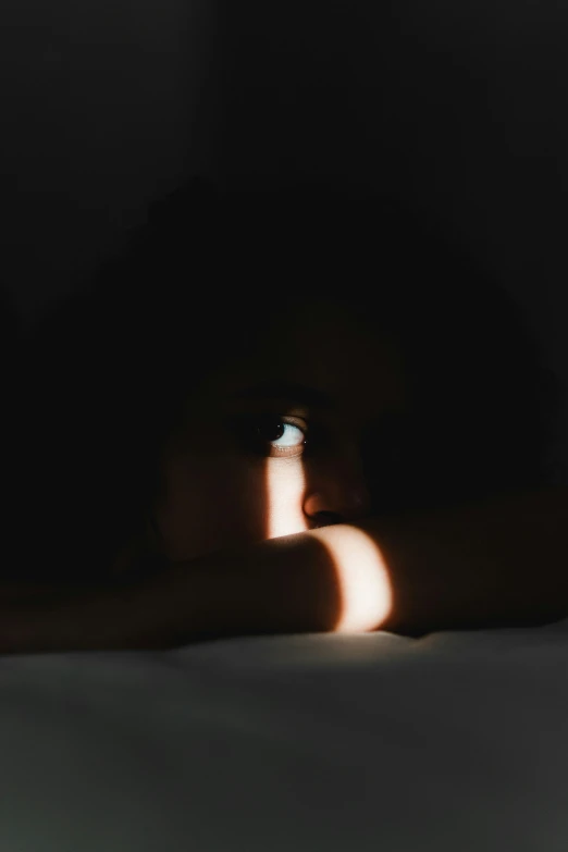 a close up of a person laying on a bed, trending on pexels, conceptual art, with huge luminous sad eyes, woman silhouette, ☁🌪🌙👩🏾, profile pic