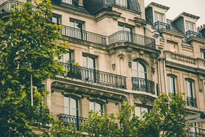 a tall building with lots of windows and balconies, a photo, inspired by Albert Paris Gütersloh, pexels, art nouveau, lush surroundings, directoire style, illustration”, features between french