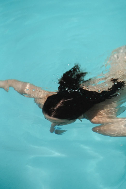 a woman swimming in a pool with a frisbee, inspired by Ren Hang, unsplash, her hair flowing down, back - shot, low quality photo, ignant