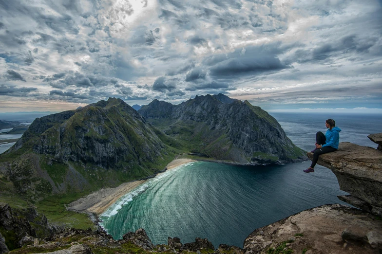 a person sitting on a rock overlooking a body of water, by Sebastian Spreng, pexels contest winner, hurufiyya, extreme panoramic, nordic, beach is between the two valleys, 8k resolution”