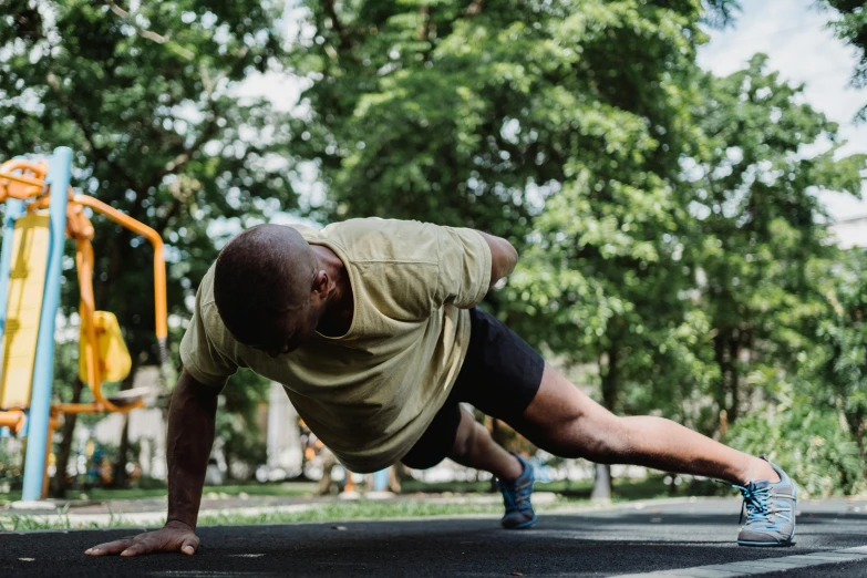 a man doing push ups in a park, a photo, pexels contest winner, man is with black skin, panoramic anamorphic, as well as scratches, thumbnail