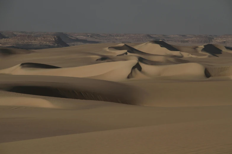 a group of sand dunes sitting in the middle of a desert, by Daniel Seghers, pexels contest winner, les nabis, muted colours 8 k, egyptian environment, beach on the outer rim, low-light