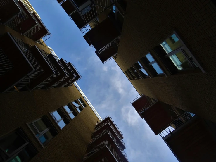 a couple of buildings that are next to each other, a picture, unsplash, precisionism, looking up onto the sky, ten flats, swedish urban landscape, viewed from bellow